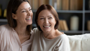 Two women at different ages smiling after a facelift in Los Altos, CA